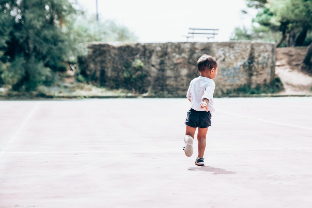 My joyful little boy running on a abandonned tennis court in south of france.