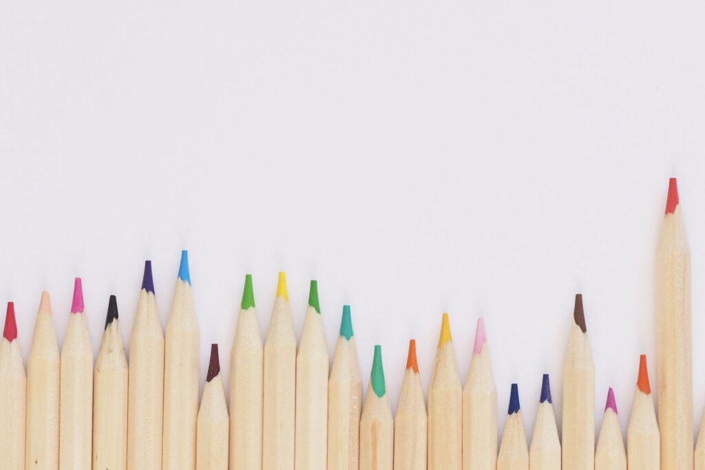 colored pencil lined up on top of white surface